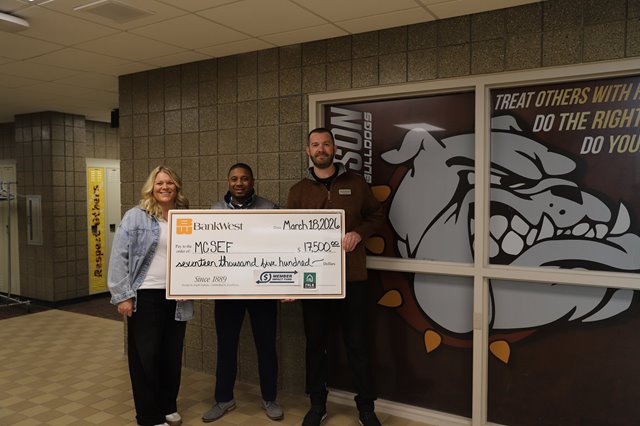 Tom Kahler, Mike Trimble present a check to Renae Prostrollo in the Madison Public school hallway