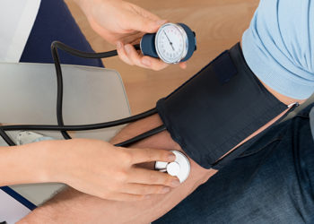 Doctor checking patient's blood pressure - HMO