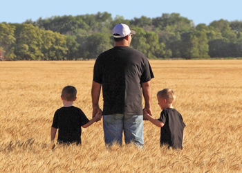 Farmer and his two sons standing in a wheat field - term life insurance